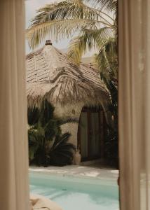 a building with a thatched roof next to a swimming pool at CASA ULU Boutique Hotel - Uluwatu, Adult-only, 6 min to Nyang Nyang beach in Uluwatu
