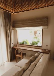 a living room with a couch in front of a window at CASA ULU Boutique Hotel - Uluwatu, Adult-only, 6 min to Nyang Nyang beach in Uluwatu