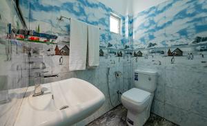 a white bathroom with a toilet and a sink at Ahungalla Ocean Villa in Ahungalla