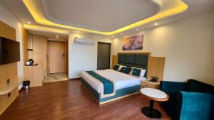 a hotel room with a bed and a couch at Jeeva Premium Rooms in Dalhousie