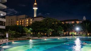 a swimming pool with the tv tower in the background at View Talay 3 Apartment in Pattaya South