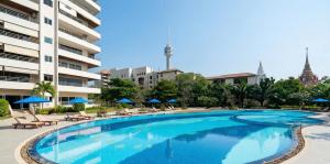 a large swimming pool with chairs and umbrellas next to a building at View Talay 3 Apartment in Pattaya South