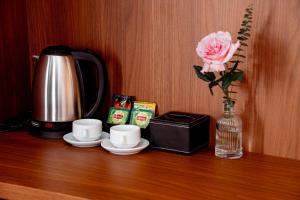 a table with two cups and a vase with a flower at Cát Boutique Hotel in Dong Hoi