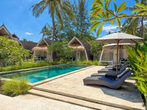 a swimming pool with two lounge chairs and an umbrella at Gili Air Escape - Adults Only in Gili Islands