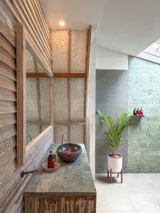 a bathroom with a sink and a plant on a table at Gili Air Escape - Adults Only in Gili Islands +28 photos