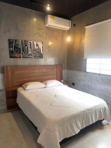 a bedroom with a large white bed and a window at El marqués casa boutique in Ríohacha