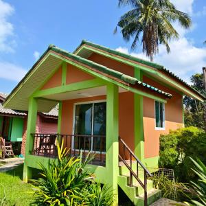 ein Haus mit einer Palme im Hintergrund in der Unterkunft The Rusty Plank in Ban Dan Kao