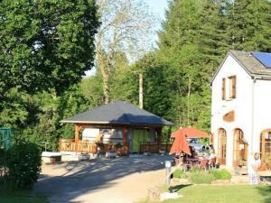 a house with a pavilion with people sitting at tables at Chalet accueillant - 4 pers. - API-1-52-2453 in Meyrueis