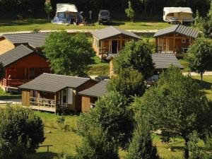 a group of houses in a field with trees at Chalet accueillant - 4 pers. - API-1-52-2453 in Meyrueis