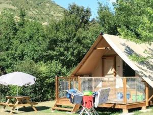 a small tent with a table and an umbrella at Chalet accueillant - 4 pers. - API-1-52-2453 in Meyrueis +22 photos