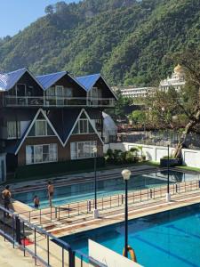 a resort with a swimming pool with mountains in the background at Da Shack in Mandi