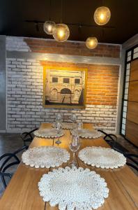 a table with white plates and wine glasses on it at El marqués casa boutique in Ríohacha