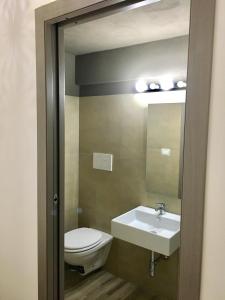 a bathroom with a sink and a toilet and a mirror at Annette Rooms in Bari