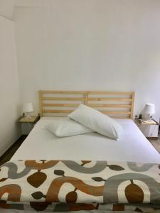 a bed with two pillows and a blanket on it at Annette Rooms in Bari