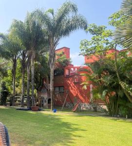a house with palm trees in front of it at Loft familiar campestre en Atlixco in Atlixco