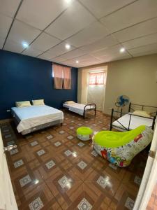 a room with two beds and a room with a playroom at Hostal Casa Colonial in Santa Ana