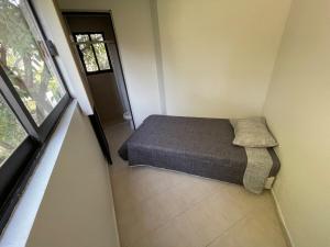 a small bedroom with a bed and a window at Loft familiar campestre en Atlixco in Atlixco