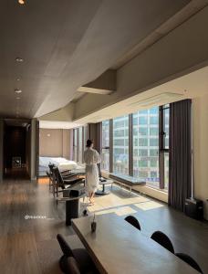 a woman standing in a hotel room looking out the window at The Moor Wellnsee Pool Villa in Busan +105 photos