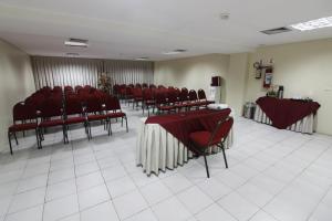 a conference room with red chairs and tables in it at IMPERIAL TAMBAU Flat by PenareiaTurBr in João Pessoa