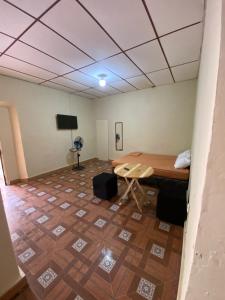 a room with a bed and a table and a tiled floor at Hostal Casa Colonial in Santa Ana