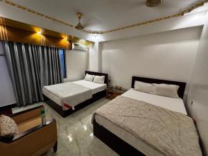 a hotel room with two beds and a tv at Hotel Seven View in Bāiljuri