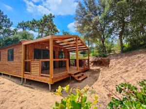 a wooden cabin on a dirt hill with trees at Appartement charmant - 4 pers. - API-1-52-2507 in Saint-Hilaire-de-Riez