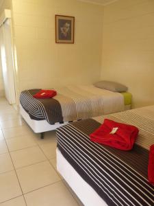 a room with two beds with red shirts on them at Chillagoe Cockatoo Hotel Motel in Chillagoe