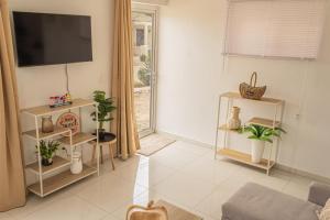 a living room with a tv on a wall at Maysi apartments in Willemstad