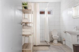 a white bathroom with a toilet and a sink at Maysi apartments in Willemstad