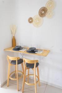 a table with two chairs and a table with plates on it at Maysi apartments in Willemstad +4 photos