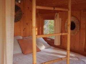 a bedroom with a bunk bed in a log cabin at Cabane cosy pour 2 avec jacuzzi - API-1-52-2485 in Saint-Amand-de-Coly