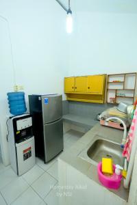 a kitchen with a sink and a refrigerator at Homestay Alkid in Timuran