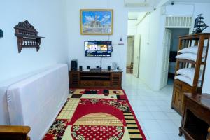 a living room with a rug on the floor at Homestay Alkid in Timuran
