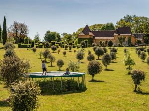 two people playing on a trampoline in a garden at Cabane cosy pour 2 avec jacuzzi - API-1-52-2485 in Saint-Amand-de-Coly