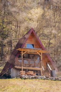 a cabin with a thatched roof in the woods at Mountain View in Tjentište
