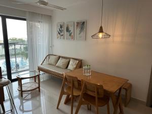 a living room with a table and a couch at Hue Oi 5 Homestay - Spacious 2-Bedroom Apartment with Balcony & Pool in Hue