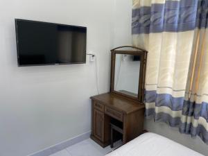 a bedroom with a mirror and a tv on the wall at Beachside home in Phú Quốc