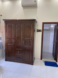 a wooden cabinet in a room with a mirror at Beachside home in Phú Quốc