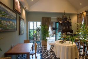 a dining room with a table and some plants at Sri Ngachang in Chiang Mai