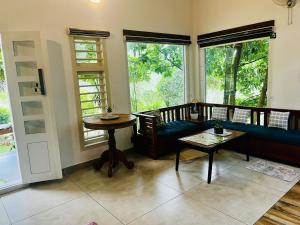 a living room with a blue couch and a table at Hidden Serene in Kalpetta