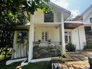 a white house with a courtyard in front of it at Hidden Serene in Kalpetta