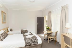 a hotel room with two beds and a table at Bathurst Motor Inn in Bathurst +64 photos