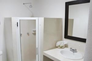a bathroom with a shower and a sink and a mirror at Hotel Berny in Isla Mujeres