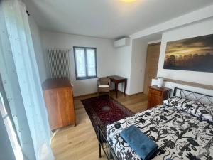 a bedroom with a bed and a desk in it at Quercia al Fiume in Ragogna