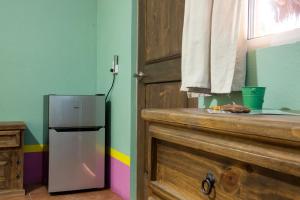 a small refrigerator in a kitchen next to a door at Casa Juarez B&B in La Paz