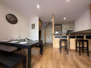 a kitchen with a black table and some chairs at Maison au cœur d’Orgelet in Orgelet