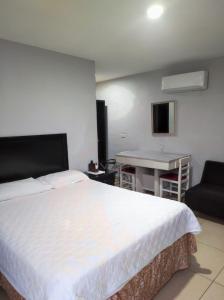 a bedroom with a bed and a table and a desk at Hgen Rooms & Suites in Los Mochis