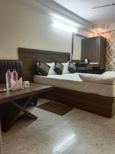 a hotel room with two beds and a table at Hotel Atithi Palace in Jabalpur
