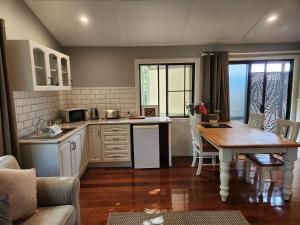 a kitchen with a table and a dining room at Hillside Hideaway - Your Base for the Region in Cawongla
