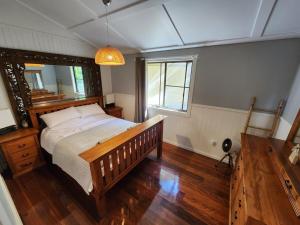 a bedroom with a large bed and a mirror at Hillside Hideaway - Your Base for the Region in Cawongla